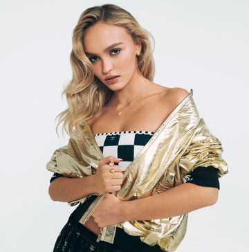 lilyrose depp poses in a gold jacket and checkerboard top